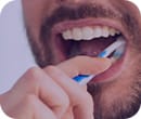man brushing his teeth to prevent gum disease